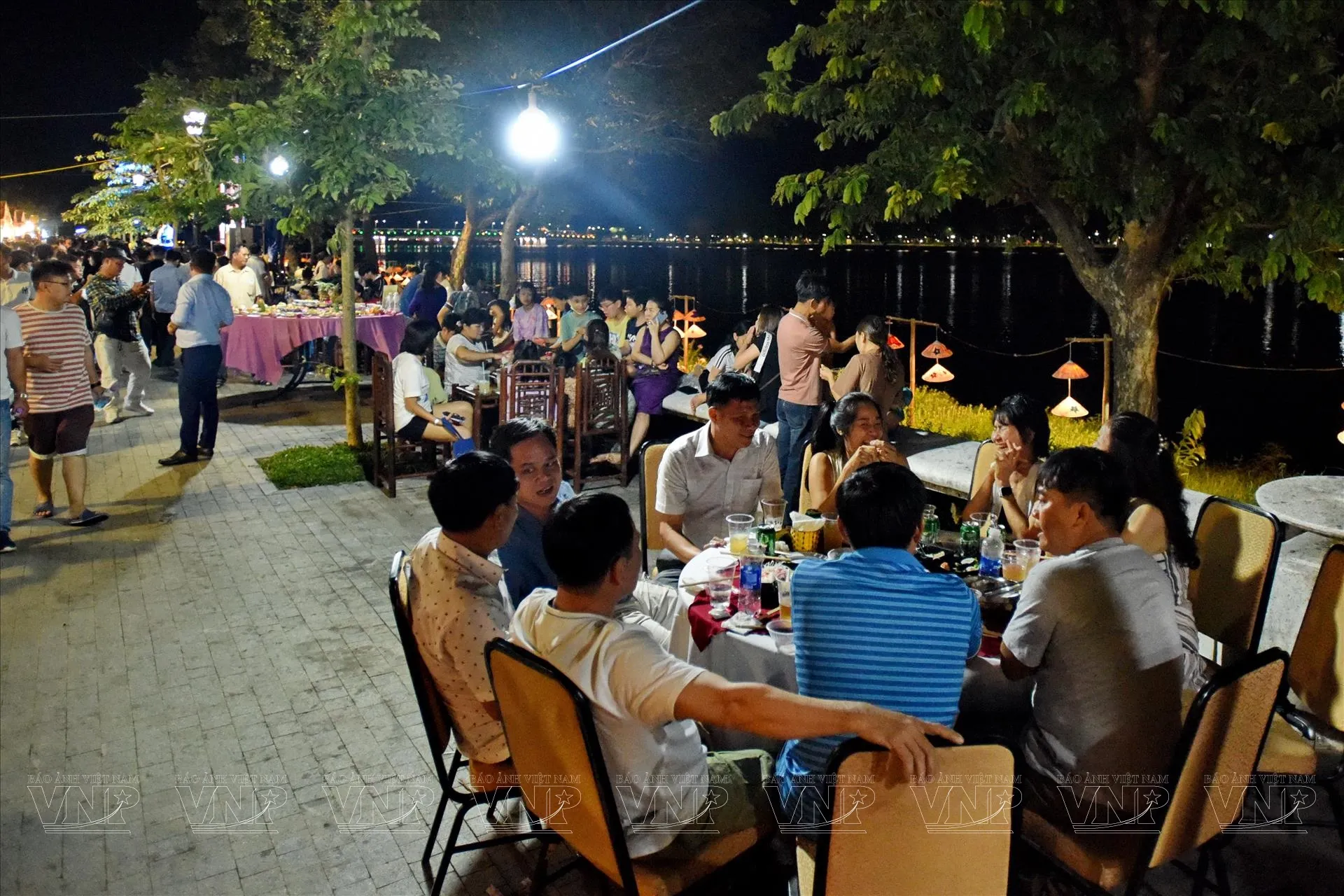 Du khách nước ngoài trải nghiệm ẩm thực đường phố bên bờ sông Hương thơ mộng ở Huế