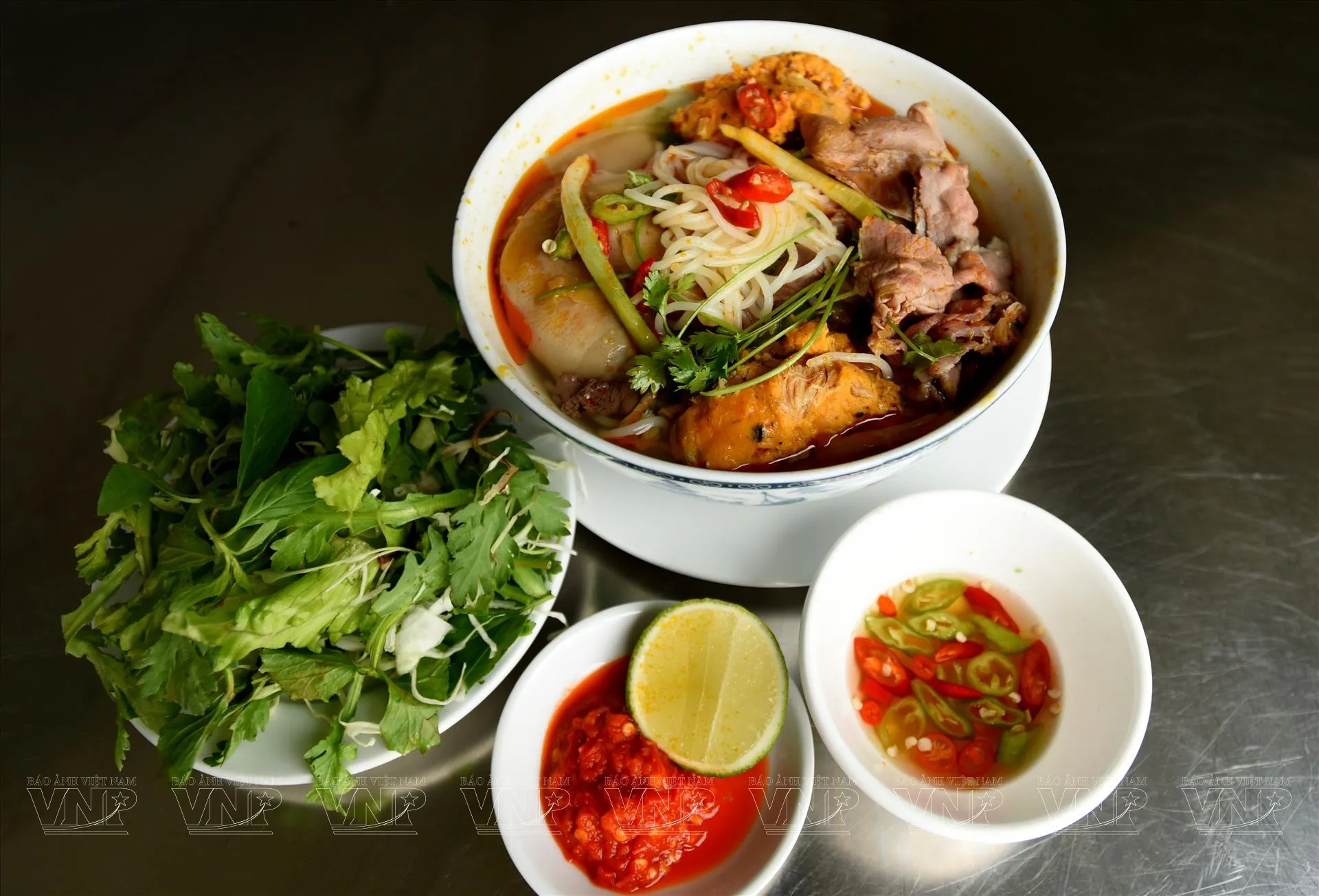 Tô bún bò Huế đầy đủ với thịt bò, giò heo và rau sống tươi xanh, món ăn được Anthony Bourdain ca ngợi