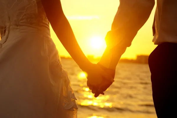 Ảnh hai người nắm tay nhau trong chiều hoàng hôn bên bờ biển lãng mạn