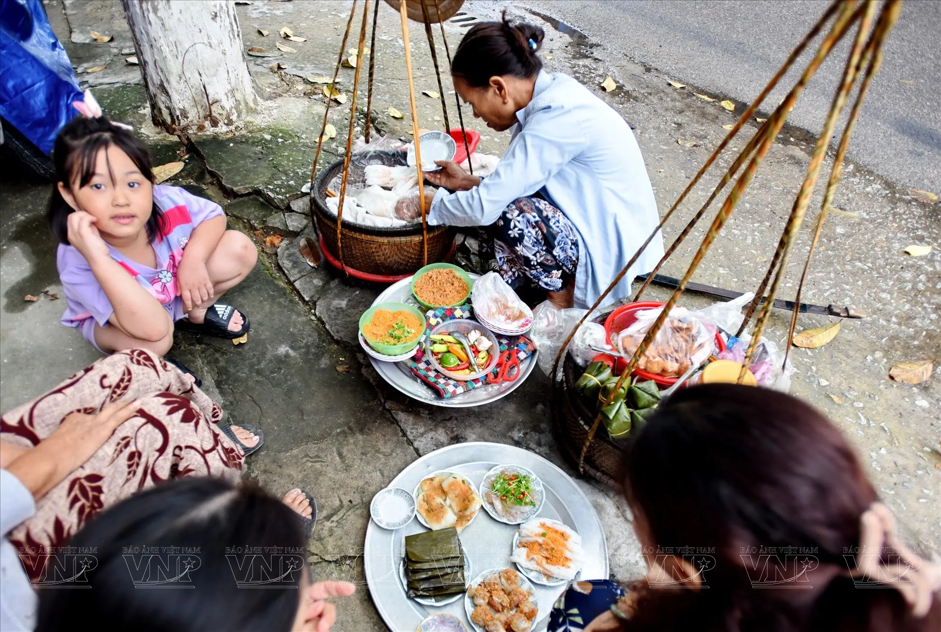 Gánh hàng rong với các loại bánh bèo, bánh nậm, bánh lọc đặc trưng của ẩm thực Huế, thu hút ánh nhìn