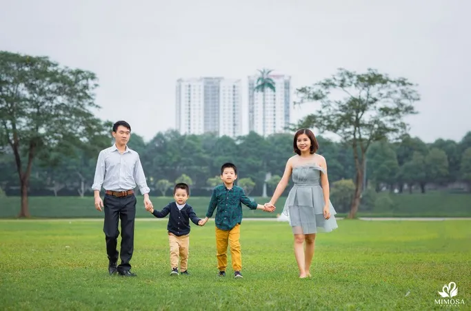 Gia đình 4 người nắm tay nhau đi bộ trên đường, thể hiện sự gắn kết