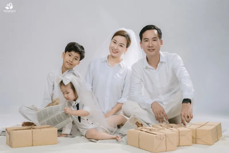 Gia đình 4 người hơi nghiêng người về phía ống kính, biểu cảm tự nhiên