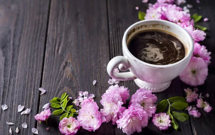 Ly cà phê và hoa hồng được sắp đặt tinh tế, gợi cảm hứng về sự hài hòa và lãng mạn.