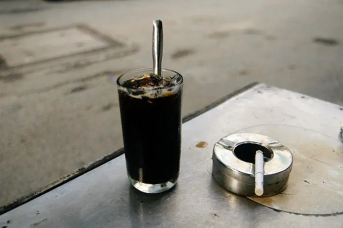 Một ly cà phê đen đá với làn khói mờ ảo, gợi lên hương thơm nồng nàn và vẻ đẹp bí ẩn.