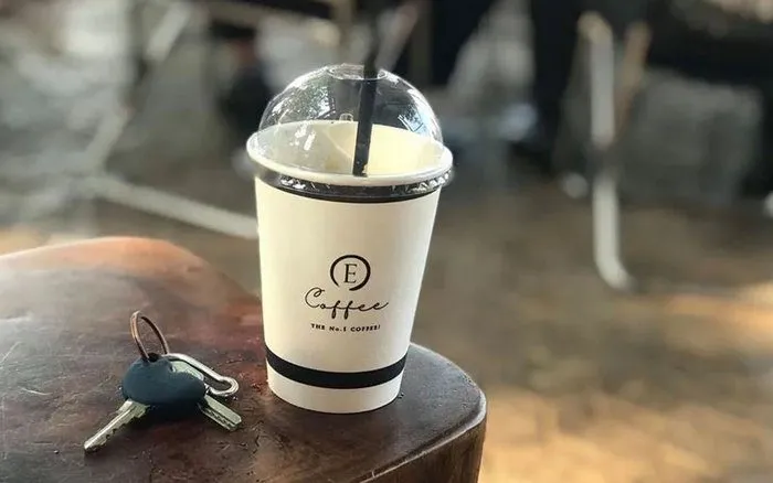 Ly cà phê mang đi với chiếc cốc giấy quen thuộc, sẵn sàng đồng hành trên mọi nẻo đường.