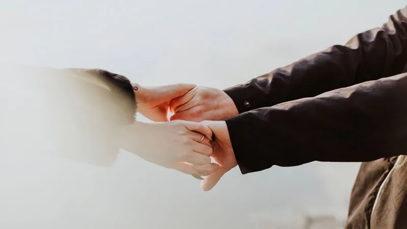 Đôi tay nắm chặt trên nền trắng tinh khiết, biểu tượng của tình yêu trong sáng