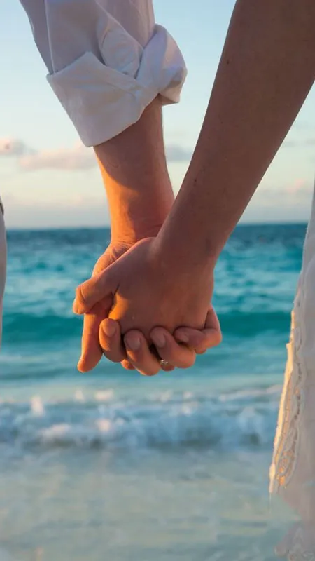 Ánh nắng vàng nhẹ chiếu lên đôi tay nắm chặt, thể hiện sự đồng điệu của tình yêu