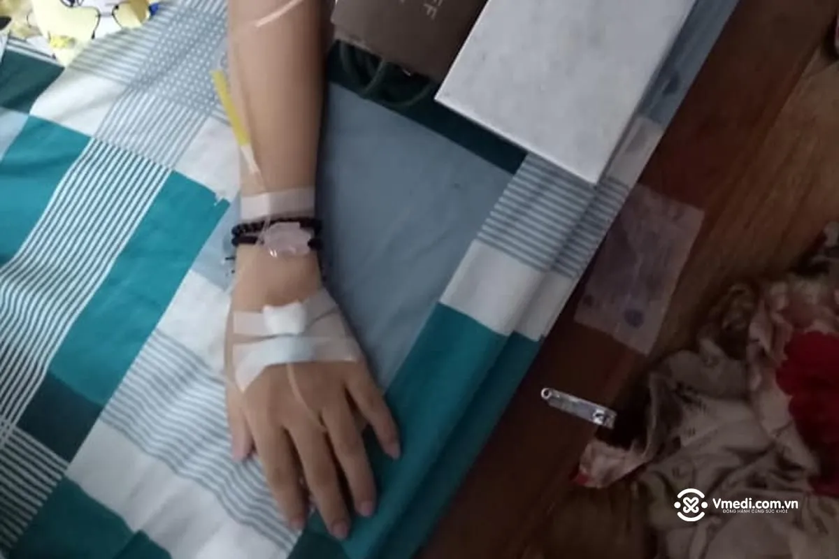 hình ảnh một phụ nữ đang truyền nước biển tại nhà, cận cảnh cánh tay
