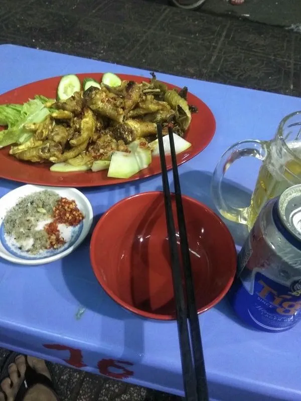 Một người đàn ông ngồi một mình bên chai rượu và ly, thể hiện nỗi buồn