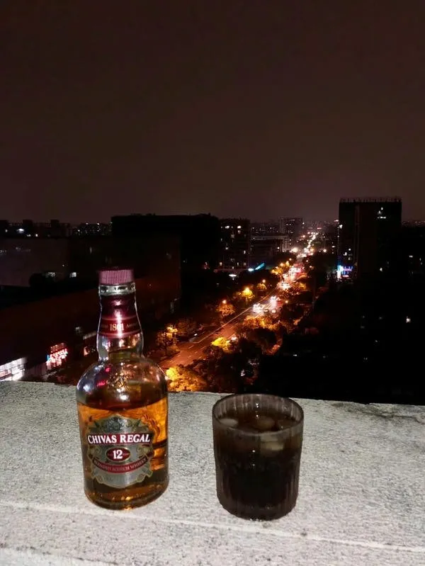 Hình ảnh bàn tay đặt trên chai rượu, thể hiện sự bất lực