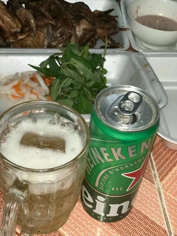 Người đàn ông ngồi nhậu một mình bên cửa sổ, nhìn ra ngoài