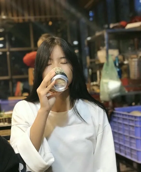 Hình ảnh một người phụ nữ ngồi nhậu một mình, thể hiện sự cô đơn